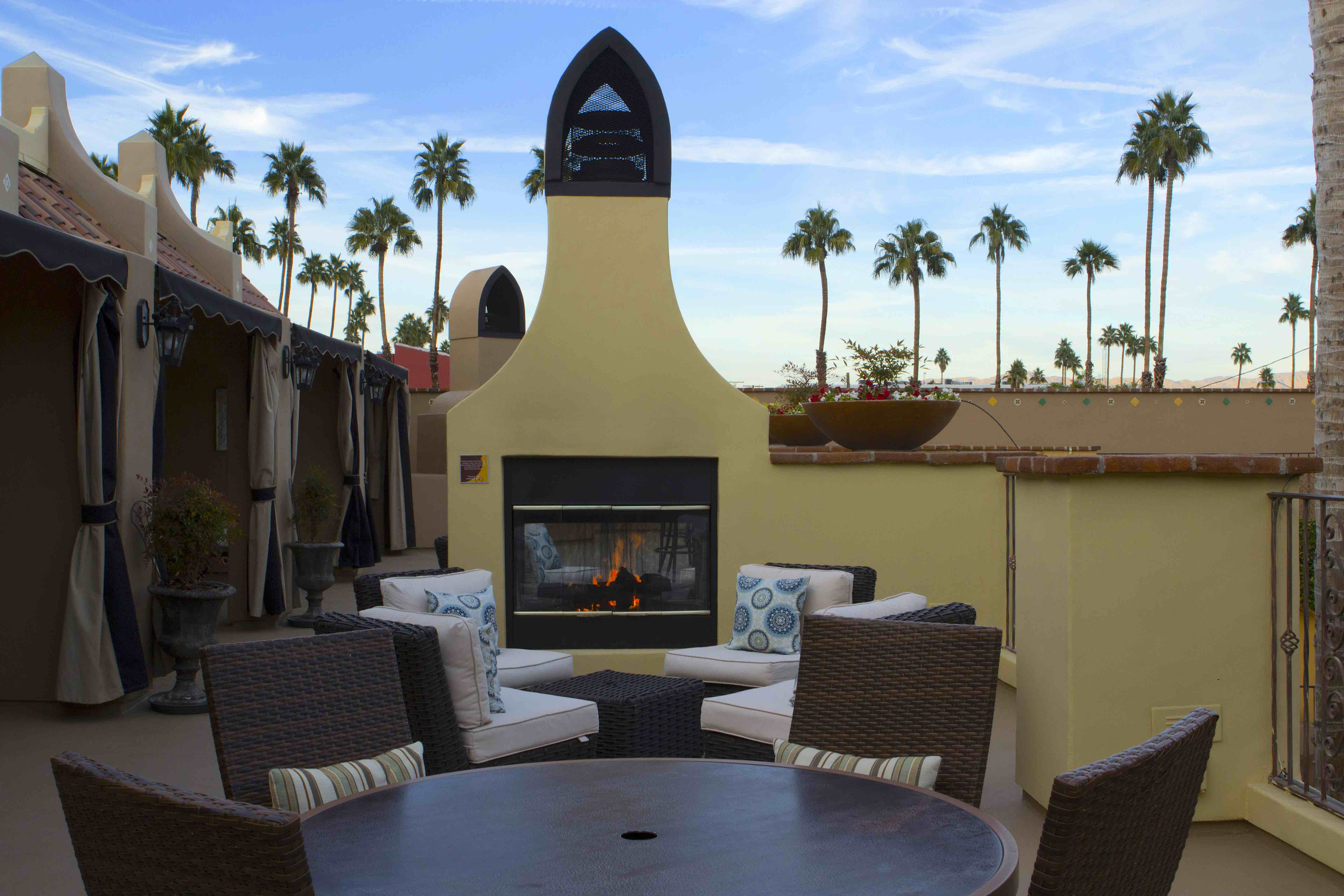 An outdoor seating area with a fireplace and wicker furniture